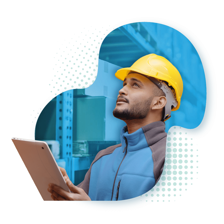 A man in a yellow hard hat and blue jacket looking upwards, holding a tablet in a warehouse environment. A graphic shape frames him with a blurred-out background.