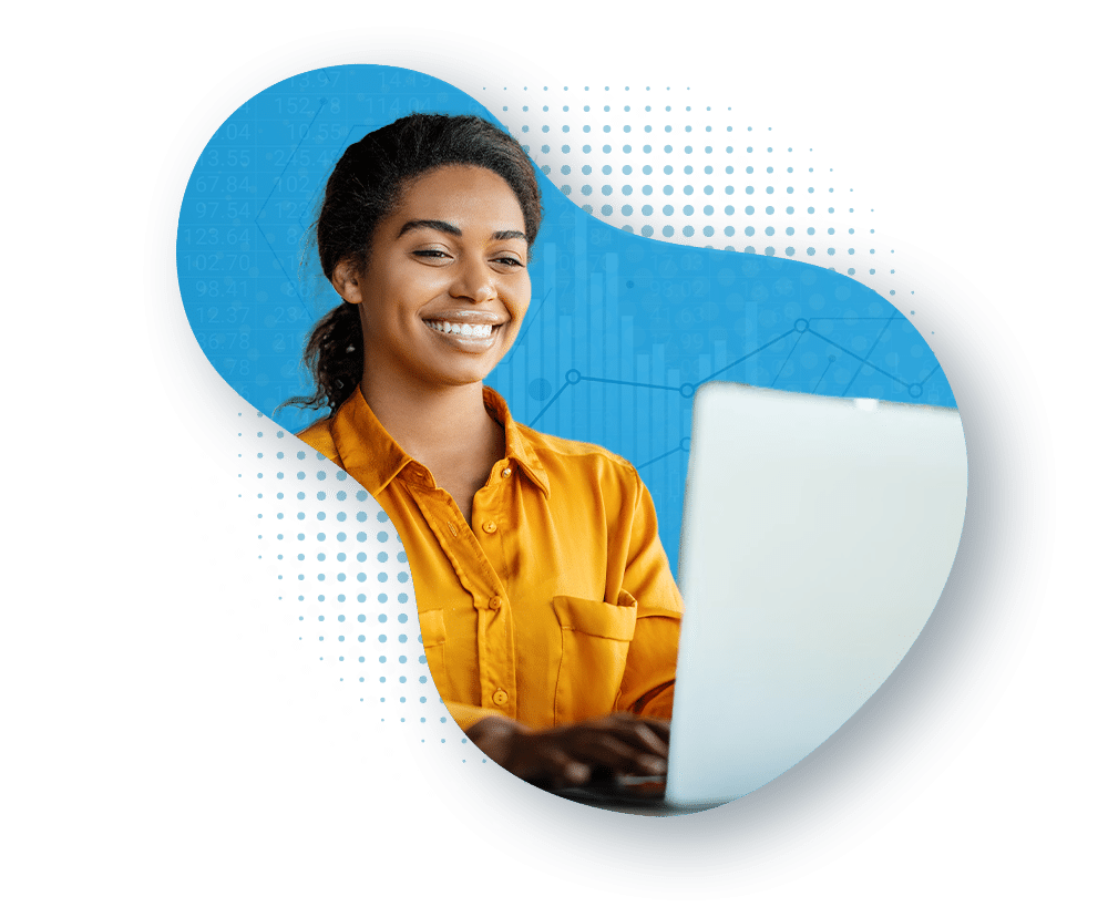 A woman smiles while working on her laptop.